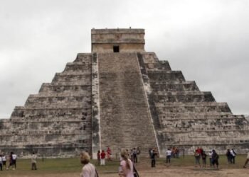 Turista sube pirámide en Chichen Itzá