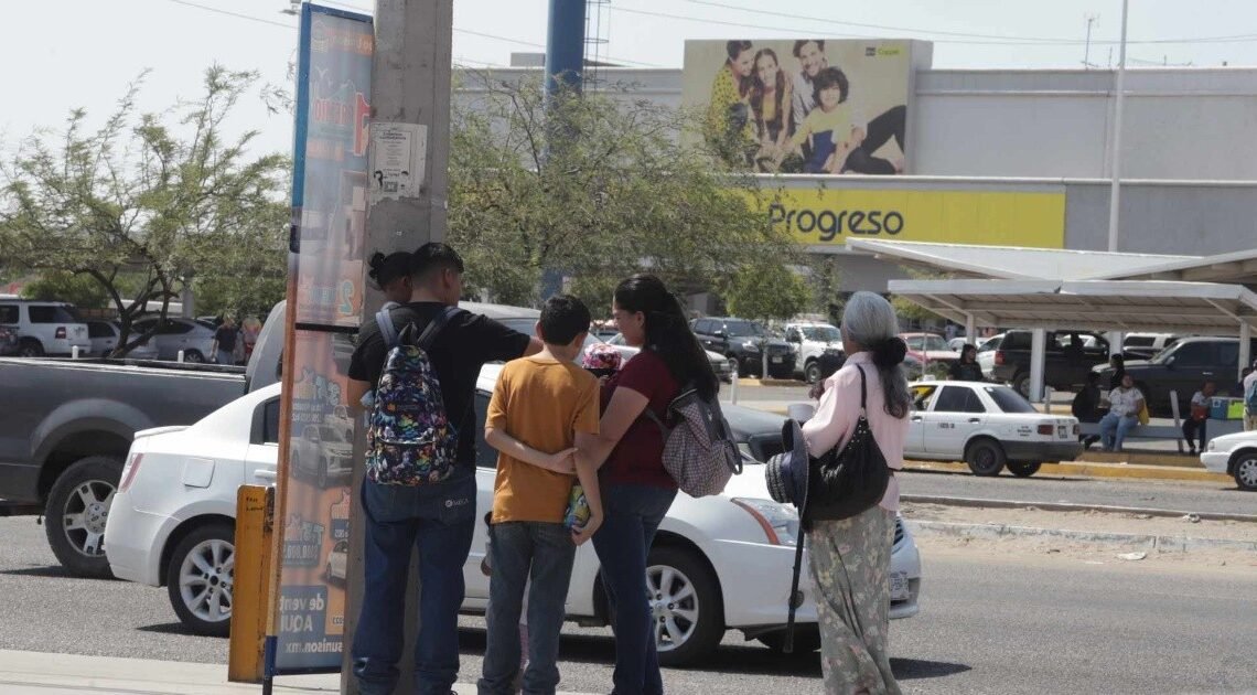 Pasajeros agotados por el calor y las largas esperas en la parada de camión
