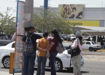 Pasajeros agotados por el calor y las largas esperas en la parada de camión